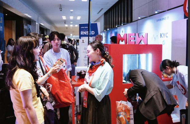 Visitors talking at a MEW community booth during a Japan activation
